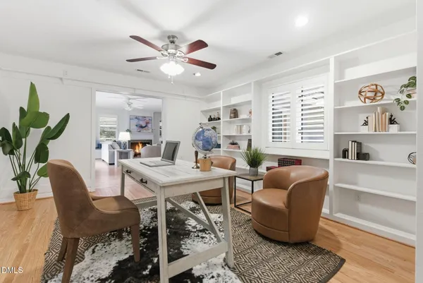 an empty room with windows and ceiling fan