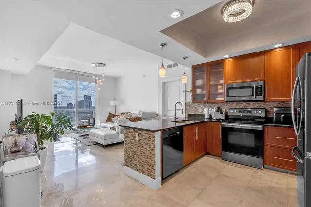 a kitchen with stainless steel appliances granite countertop a stove refrigerator and sink