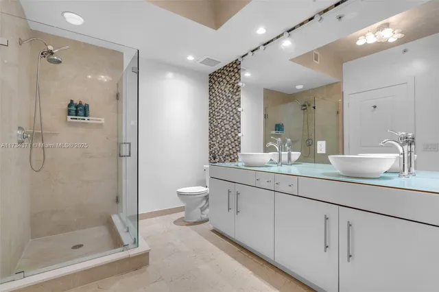 a bathroom with a shower sink vanity and mirror