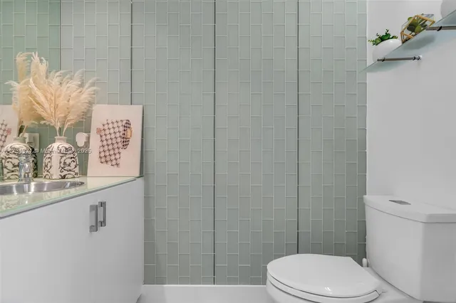 a white toilet sitting next to a shower
