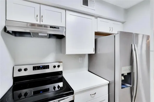 a kitchen with stainless steel appliances a refrigerator and a stove