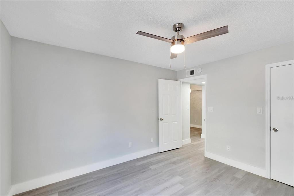 8718 Mallard Reserve Drive, Unit 101 Tampa, FL 33614 - Photo 16 of 25 an empty room with wooden floor ceiling fan and window