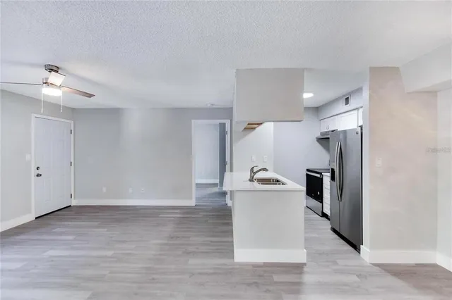 a view of a kitchen with a sink and refrigerator