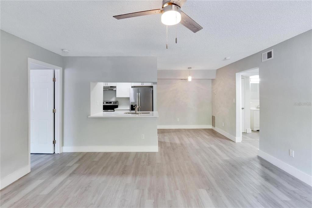 8718 Mallard Reserve Drive, Unit 101 Tampa, FL 33614 - Photo 4 of 25 a view of a room with wooden floor and a ceiling fan