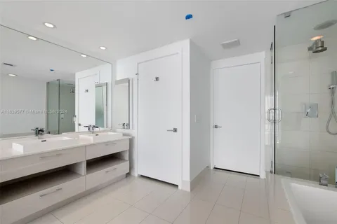 a bathroom with a tub shower and vanity