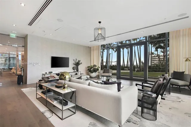 a living room with couches and kitchen view with wooden floor