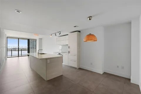 a large kitchen with a lot of cabinets and wooden floor