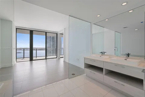 a large white room with wooden floor and garden view