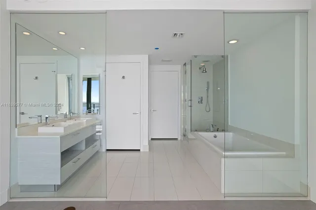 a bathroom with a bathtub shower sink and mirror