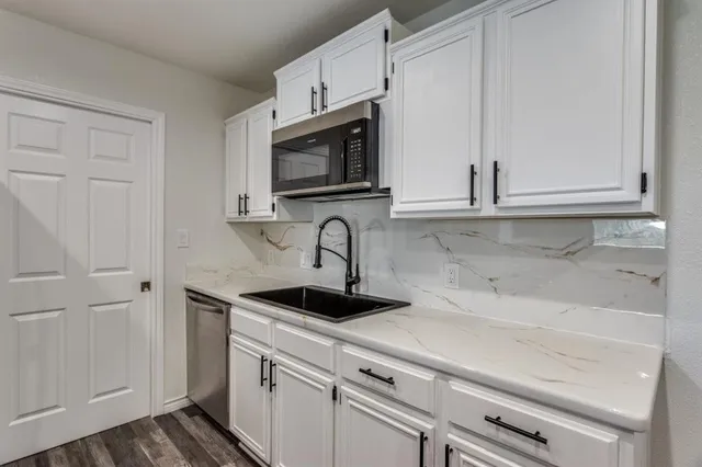 a kitchen with white cabinets and a sink