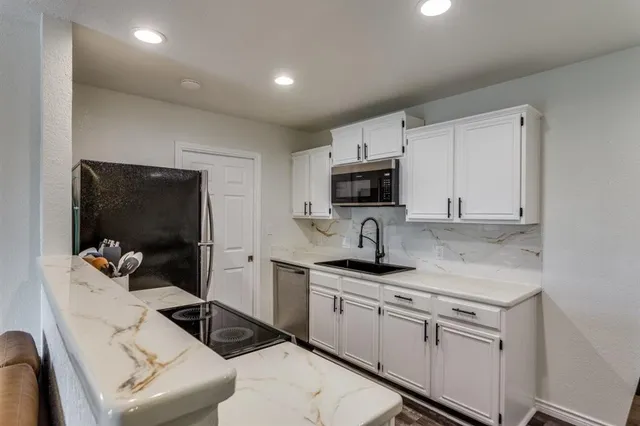 a kitchen with granite countertop white cabinets and appliances