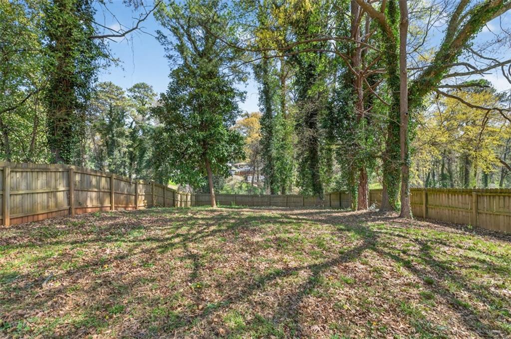 3061 Glendale Court Decatur, GA 30032 - Photo 21 of 21 a backyard of a house with large trees and a wooden fence