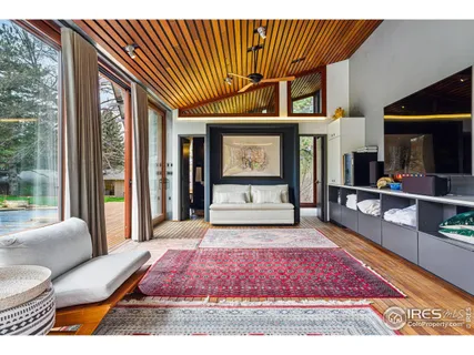 a spacious bedroom with a bed and a flat screen tv