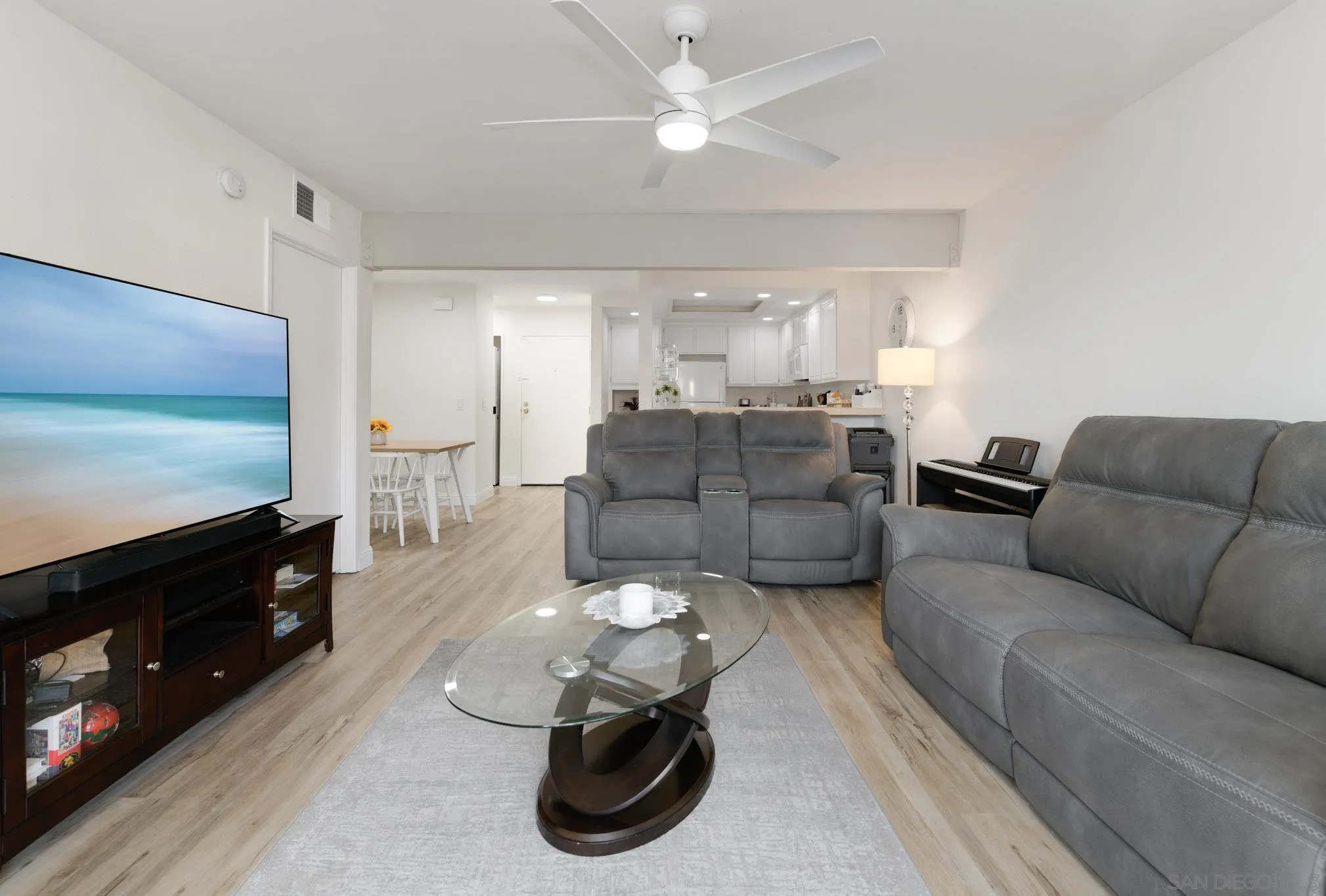 6877 Caminito Mundo, Unit 25 San Diego, CA 92119 - Photo 15 of 28 a living room with furniture a flat screen tv and kitchen view