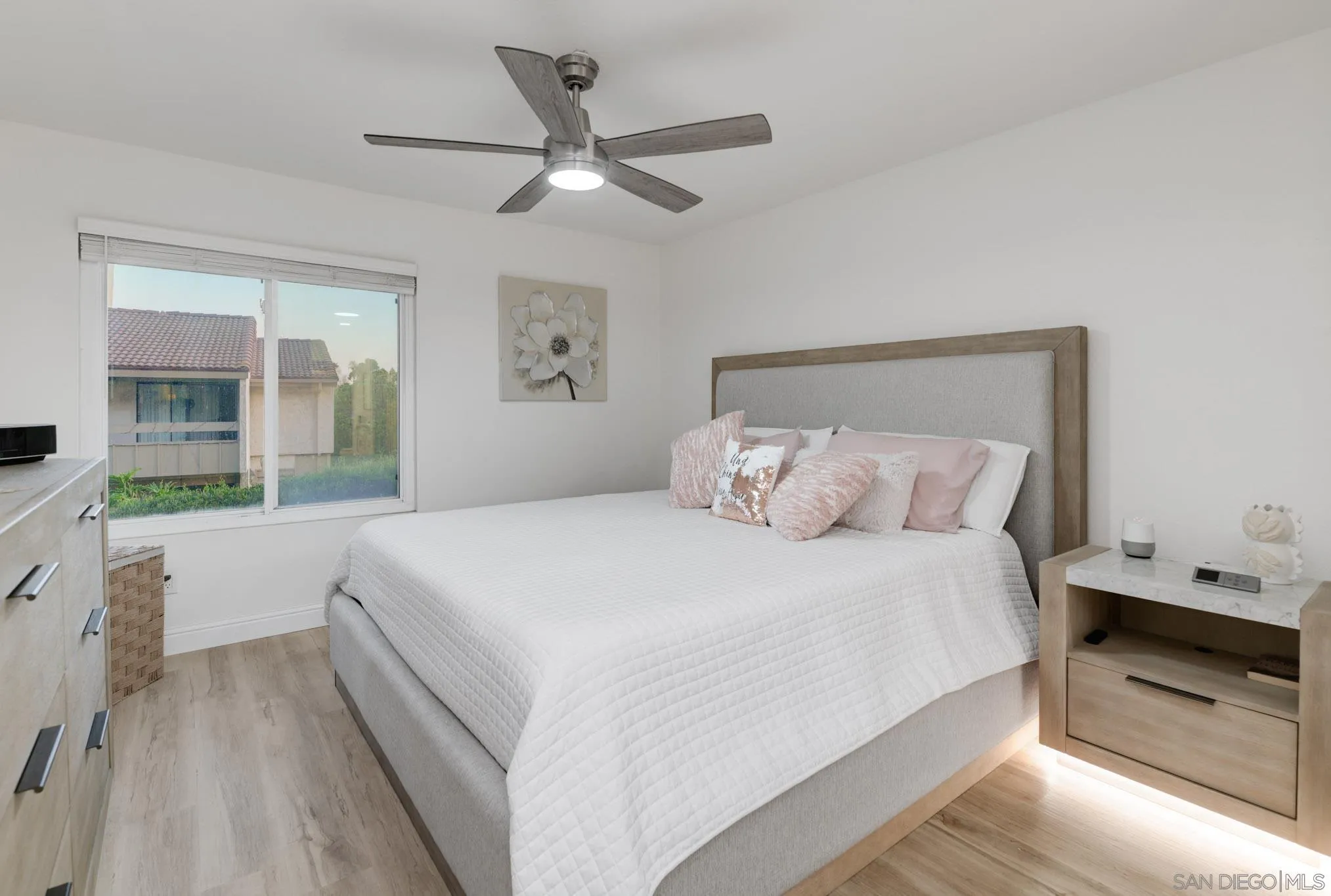 6877 Caminito Mundo, Unit 25 San Diego, CA 92119 - Photo 18 of 28 a bedroom with a large bed and a chandelier