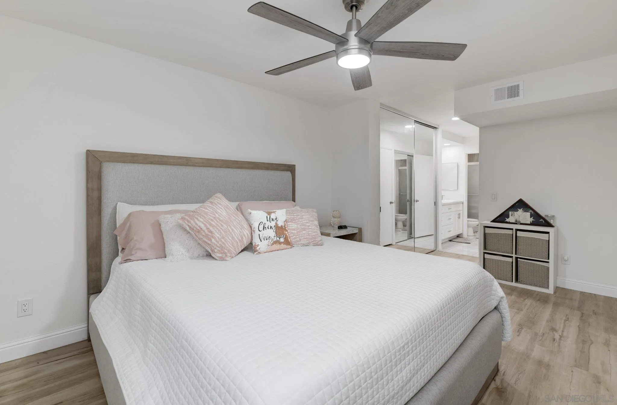 6877 Caminito Mundo, Unit 25 San Diego, CA 92119 - Photo 19 of 28 a bedroom with a large bed and a chandelier