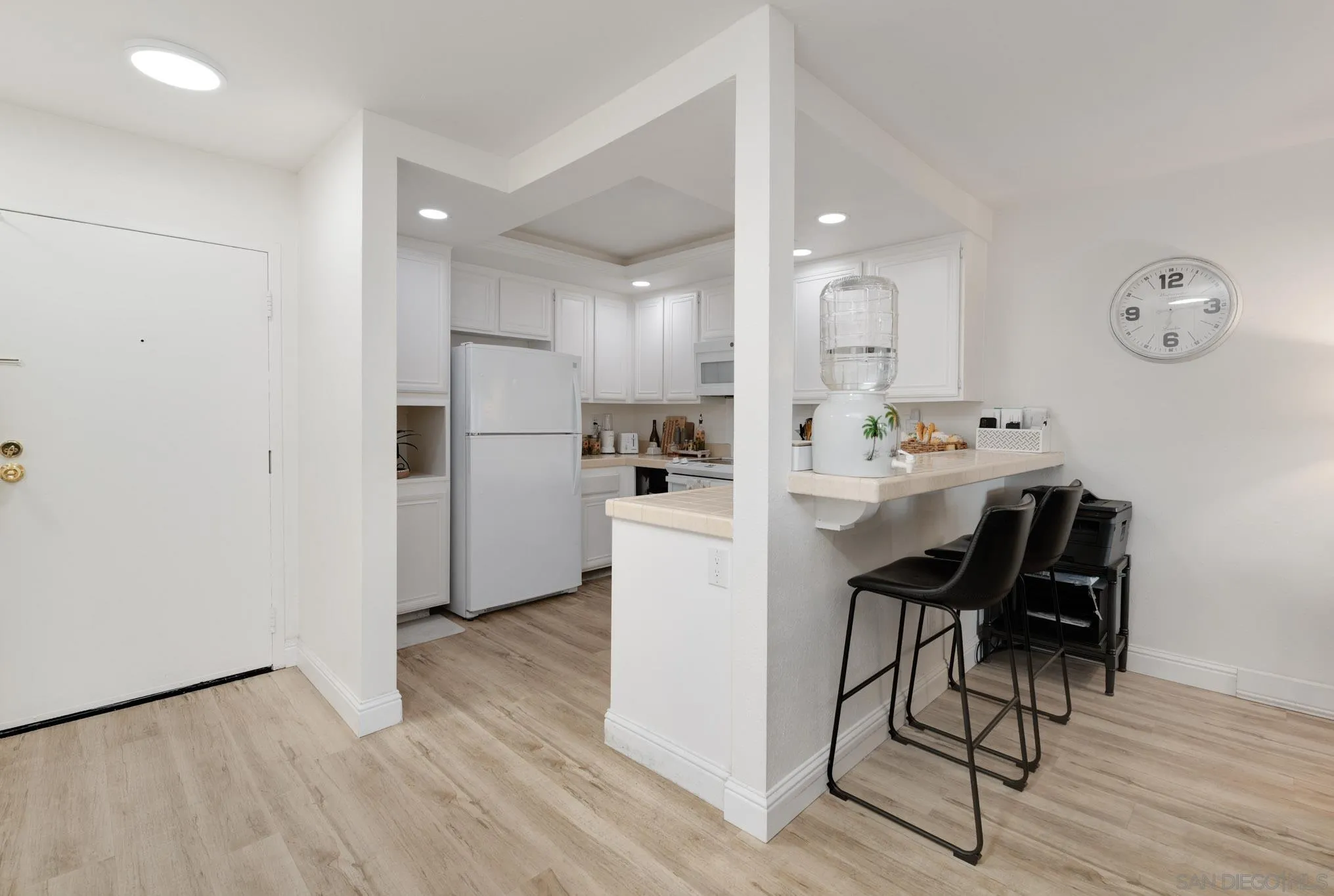 6877 Caminito Mundo, Unit 25 San Diego, CA 92119 - Photo 6 of 28 a kitchen with a refrigerator a dining table and chairs