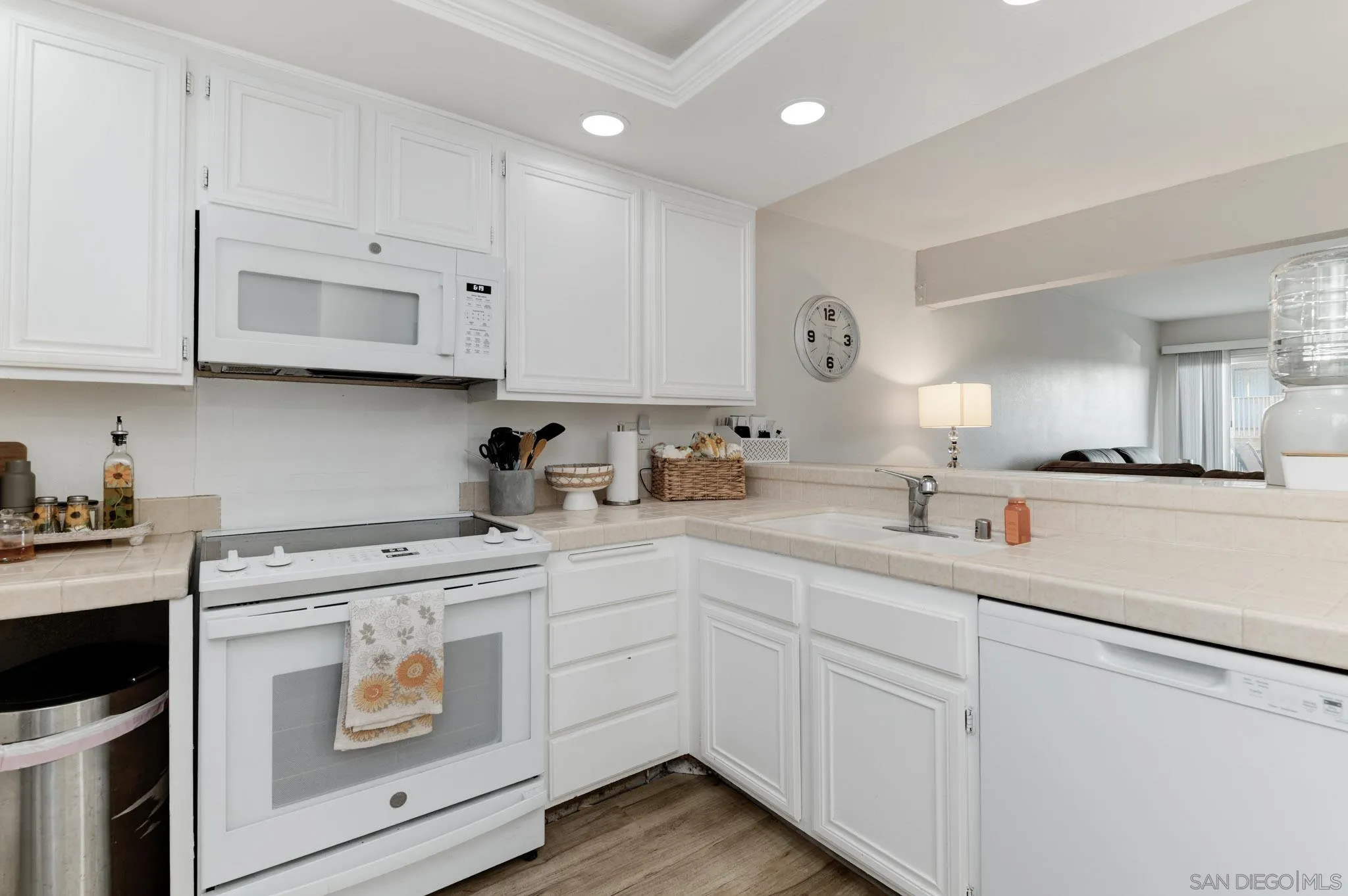6877 Caminito Mundo, Unit 25 San Diego, CA 92119 - Photo 7 of 28 a kitchen with white cabinets sink and white appliances