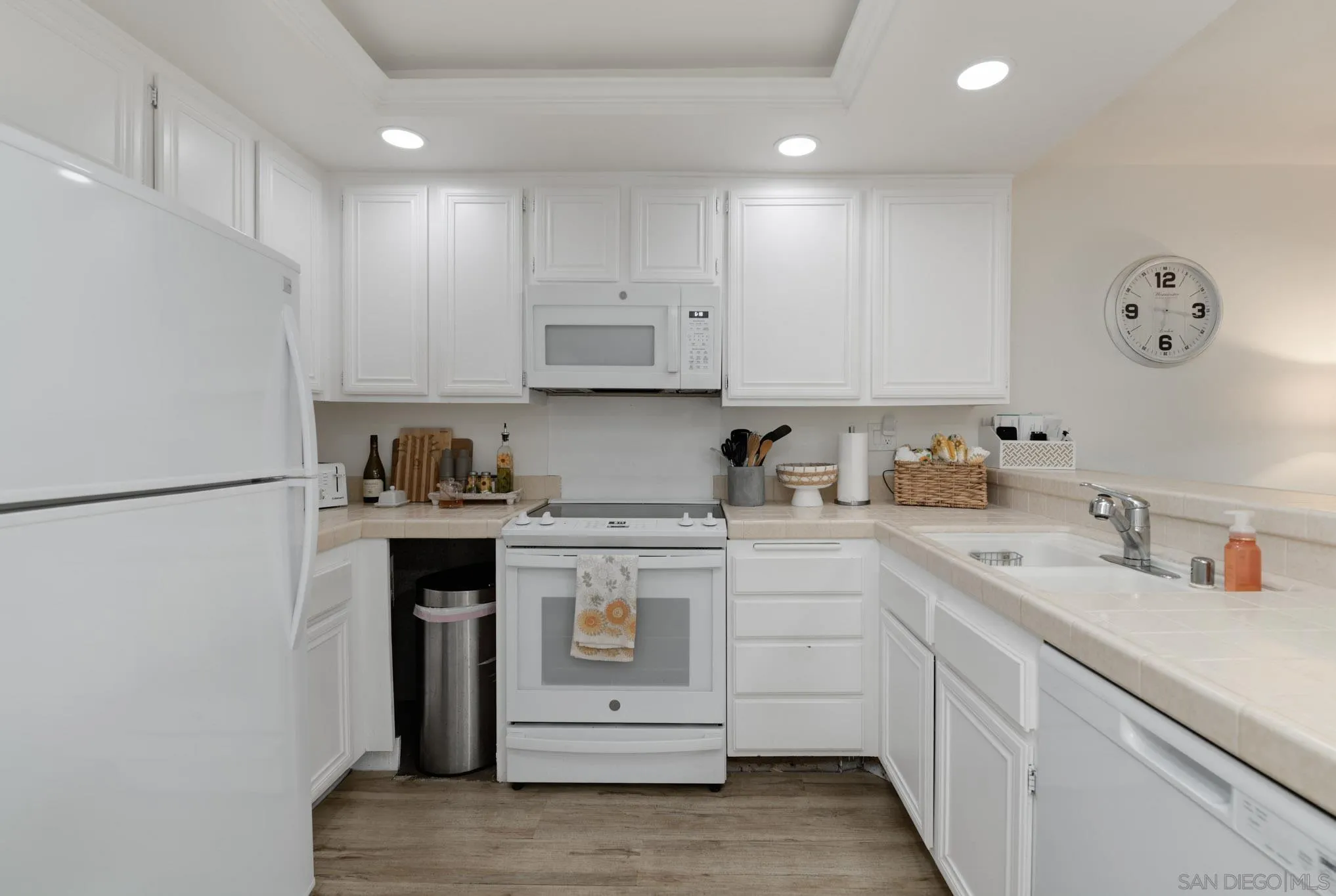 6877 Caminito Mundo, Unit 25 San Diego, CA 92119 - Photo 8 of 28 a kitchen with white cabinets and white appliances