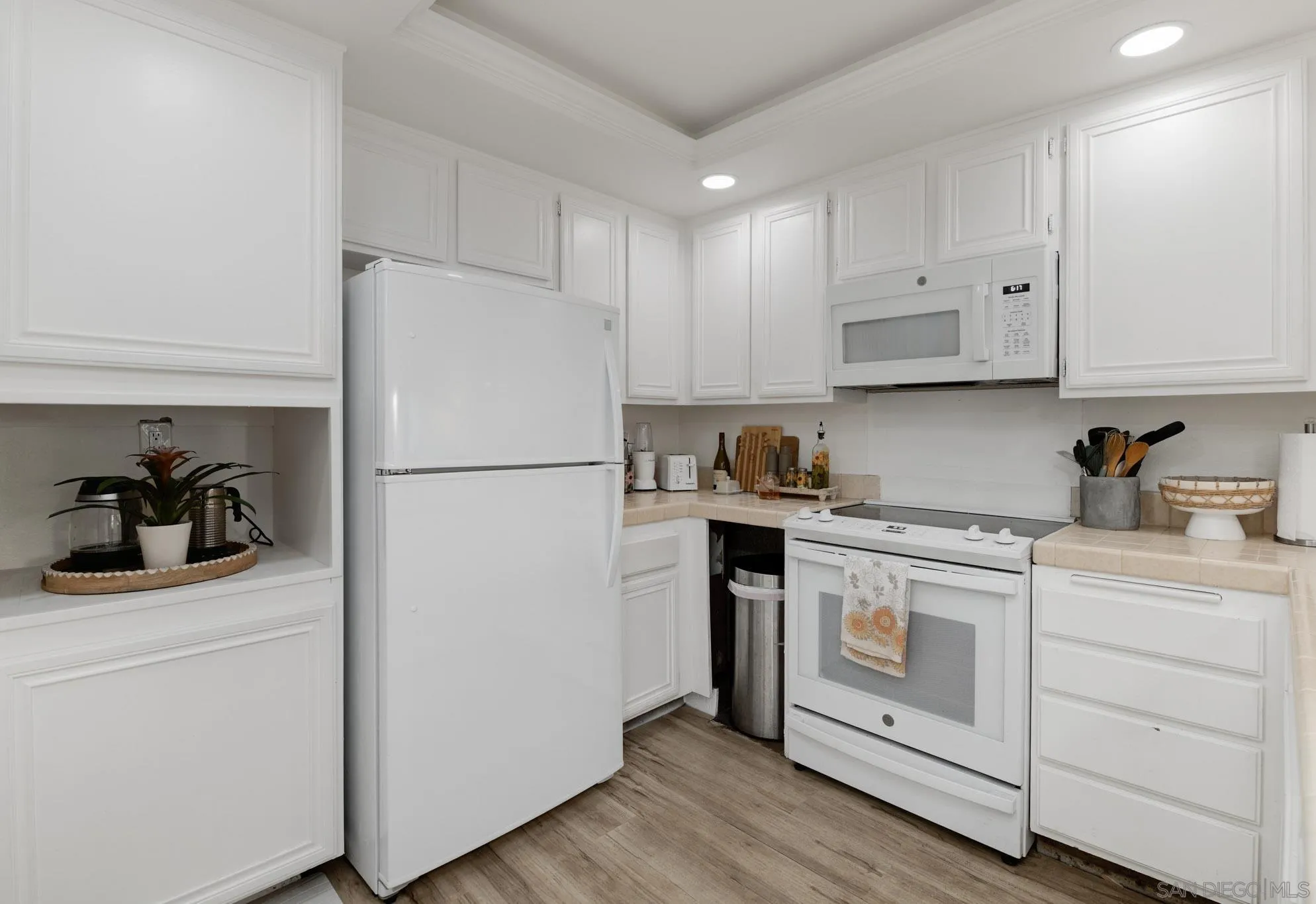 6877 Caminito Mundo, Unit 25 San Diego, CA 92119 - Photo 9 of 28 a kitchen with a refrigerator stove and white cabinets