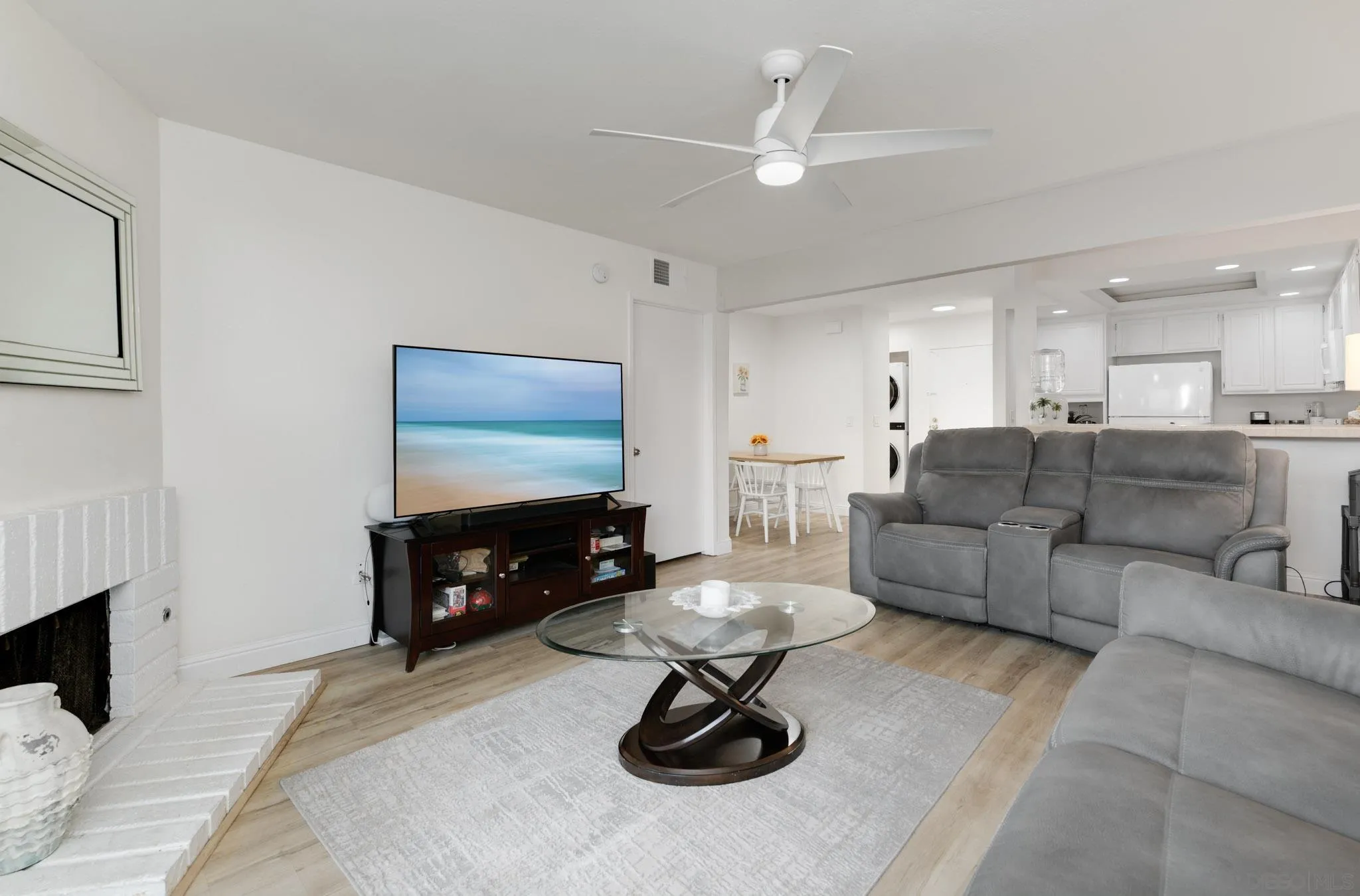 6877 Caminito Mundo, Unit 25 San Diego, CA 92119 - Photo 10 of 28 a living room with furniture a fireplace and a flat screen tv