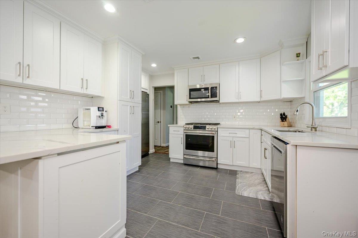 534 Allen Road Woodmere, NY 11598 - Photo 8 of 35 a kitchen with kitchen island granite countertop white cabinets white stainless steel appliances with a sink and dishwasher