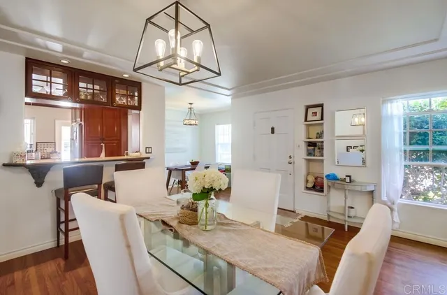 a view of a dining room with furniture a chandelier and wooden floor