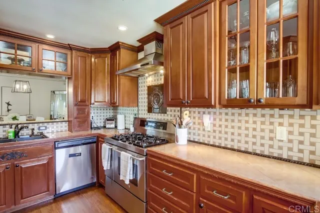 a kitchen with stainless steel appliances a sink stove and cabinets