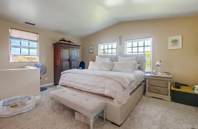 a bedroom with a bed and a window with cabinet