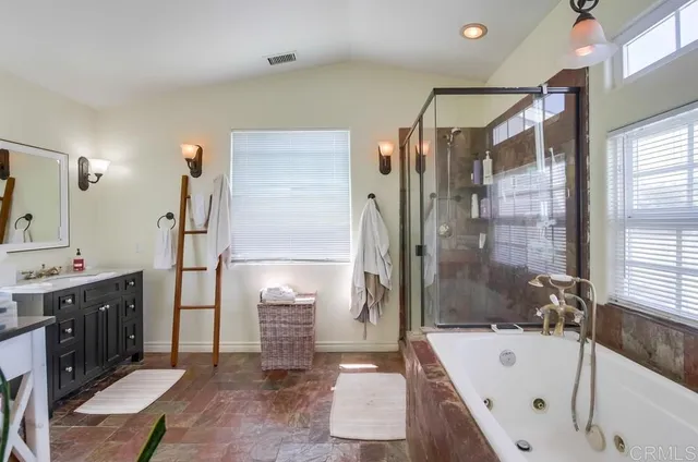 a bathroom with a tub sink shower and mirror