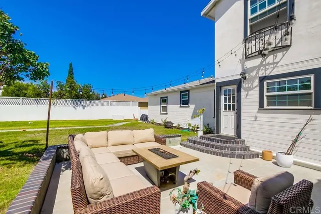a view of a patio with couches potted plants and wooden floor