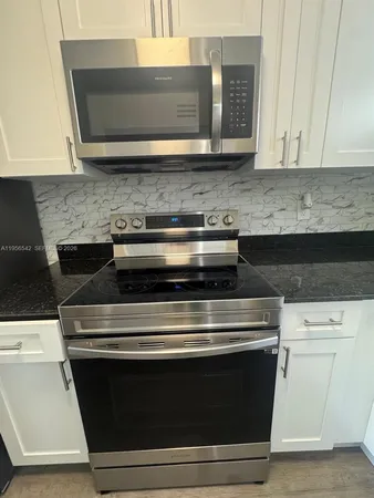 a stove top oven sitting inside of a kitchen
