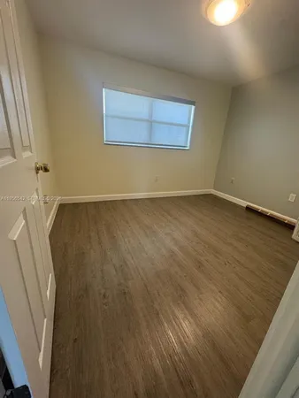 a view of a room with wooden floor and cabinet
