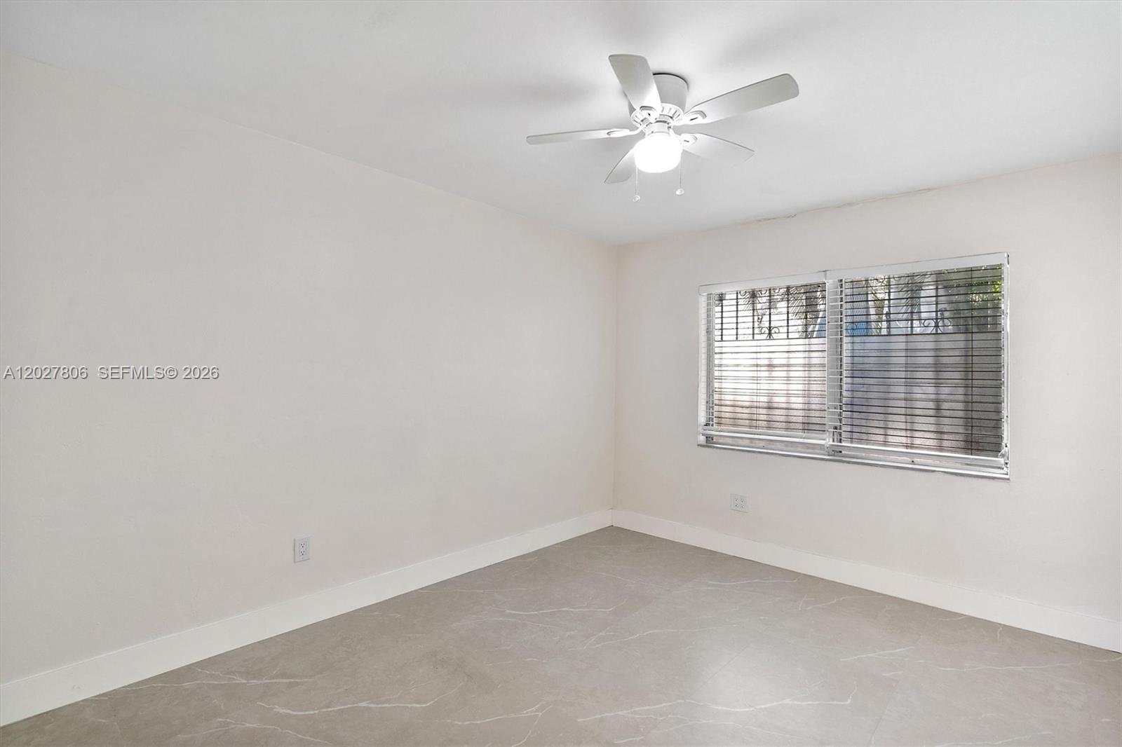 1612 Southwest 23rd Street, Unit 1612 Miami, FL 33145 - Photo 32 of 42 an empty room with chandelier fan and windows