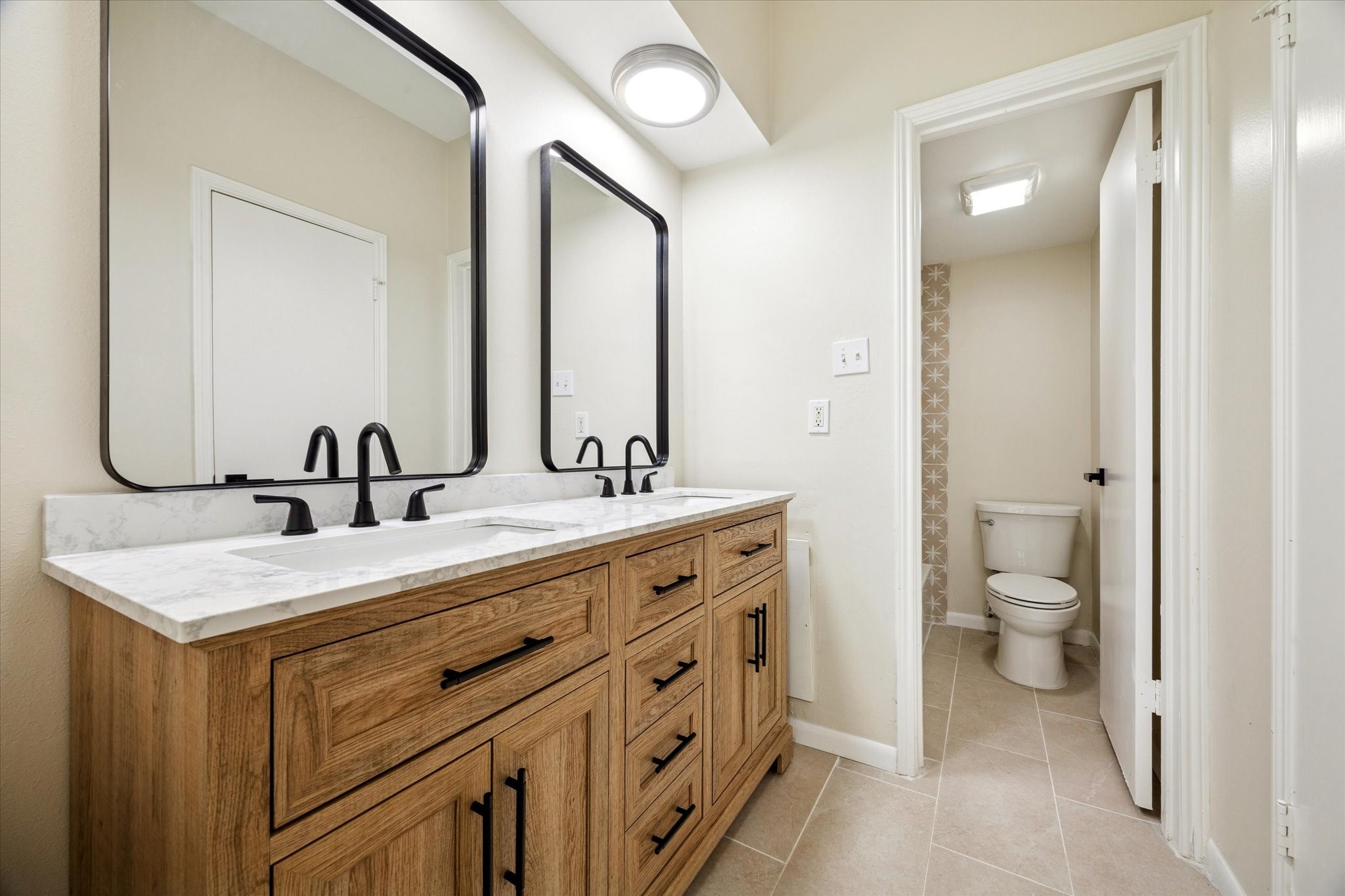 2100 Tanglewilde Street, Unit 195 Houston, TX 77063 - Photo 22 of 34 a bathroom with a double vanity sink and a toilet