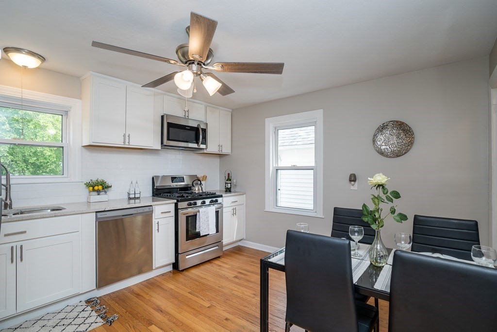 185 Pasco Road Springfield, MA 01151 - Photo 2 of 34 a kitchen with stainless steel appliances granite countertop a stove top oven a sink a dining table and chairs with wooden floor