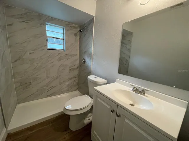 a bathroom with a sink a toilet and shower