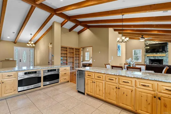a large kitchen with kitchen island a large window a sink appliances and cabinets