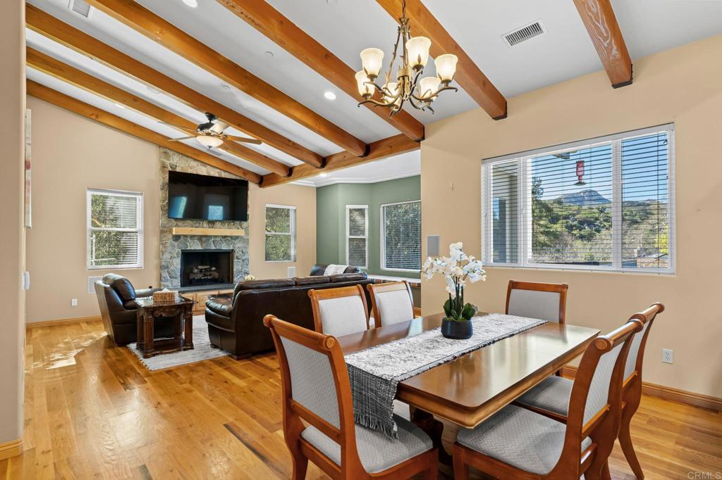 14671 Mussey Grade Road Ramona, CA 92065 - Photo 16 of 36 a dining room with furniture a fireplace and wooden floor