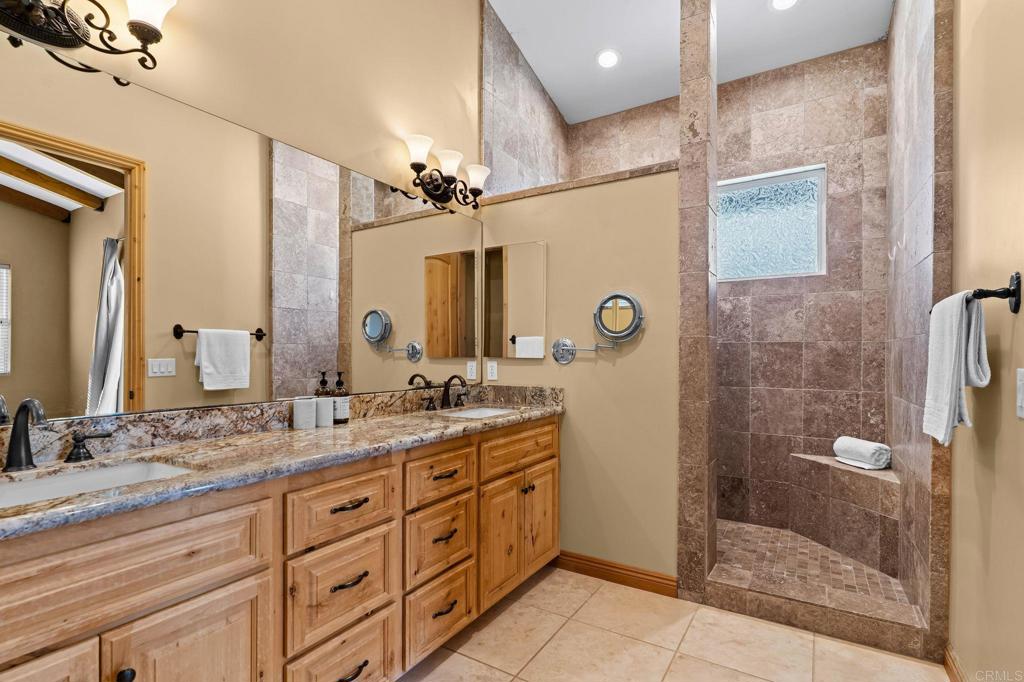 14671 Mussey Grade Road Ramona, CA 92065 - Photo 18 of 36 a bathroom with a granite countertop sink mirror shower and double