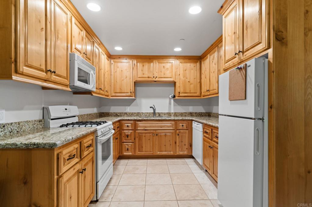 14671 Mussey Grade Road Ramona, CA 92065 - Photo 19 of 36 a kitchen with stainless steel appliances granite countertop a refrigerator a sink dishwasher a stove with wooden cabinets and floor