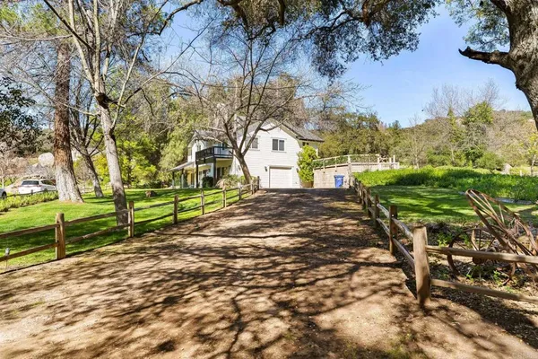 a view of a house with a big yard and swimming pool