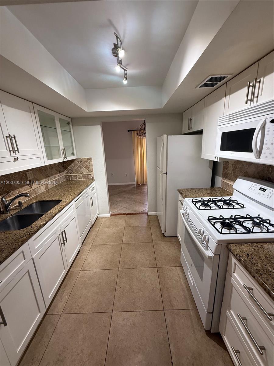 10661 Southwest 113th Place, Unit 94B Miami, FL 33176 - Photo 11 of 54 a kitchen with a stove and a sink