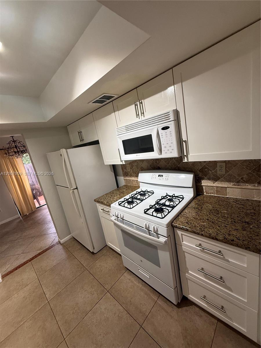 10661 Southwest 113th Place, Unit 94B Miami, FL 33176 - Photo 13 of 54 a kitchen that has a stove and a microwave