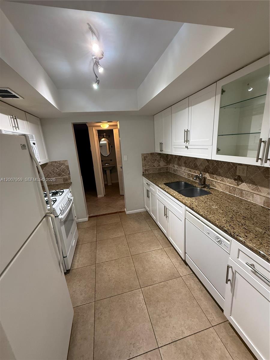 10661 Southwest 113th Place, Unit 94B Miami, FL 33176 - Photo 14 of 54 a kitchen with granite countertop cabinets and utility