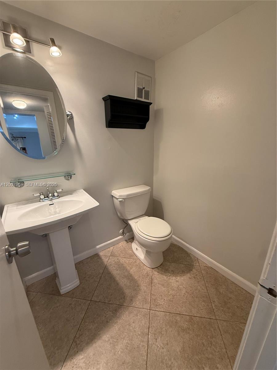 10661 Southwest 113th Place, Unit 94B Miami, FL 33176 - Photo 15 of 54 a bathroom with a sink toilet and mirror