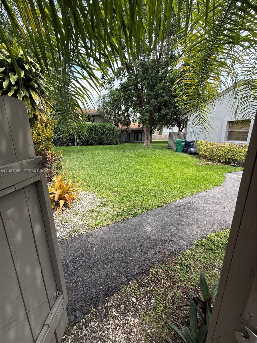 10661 Southwest 113th Place, Unit 94B Miami, FL 33176 - Photo 21 of 54 a view of a yard with plants and a large tree