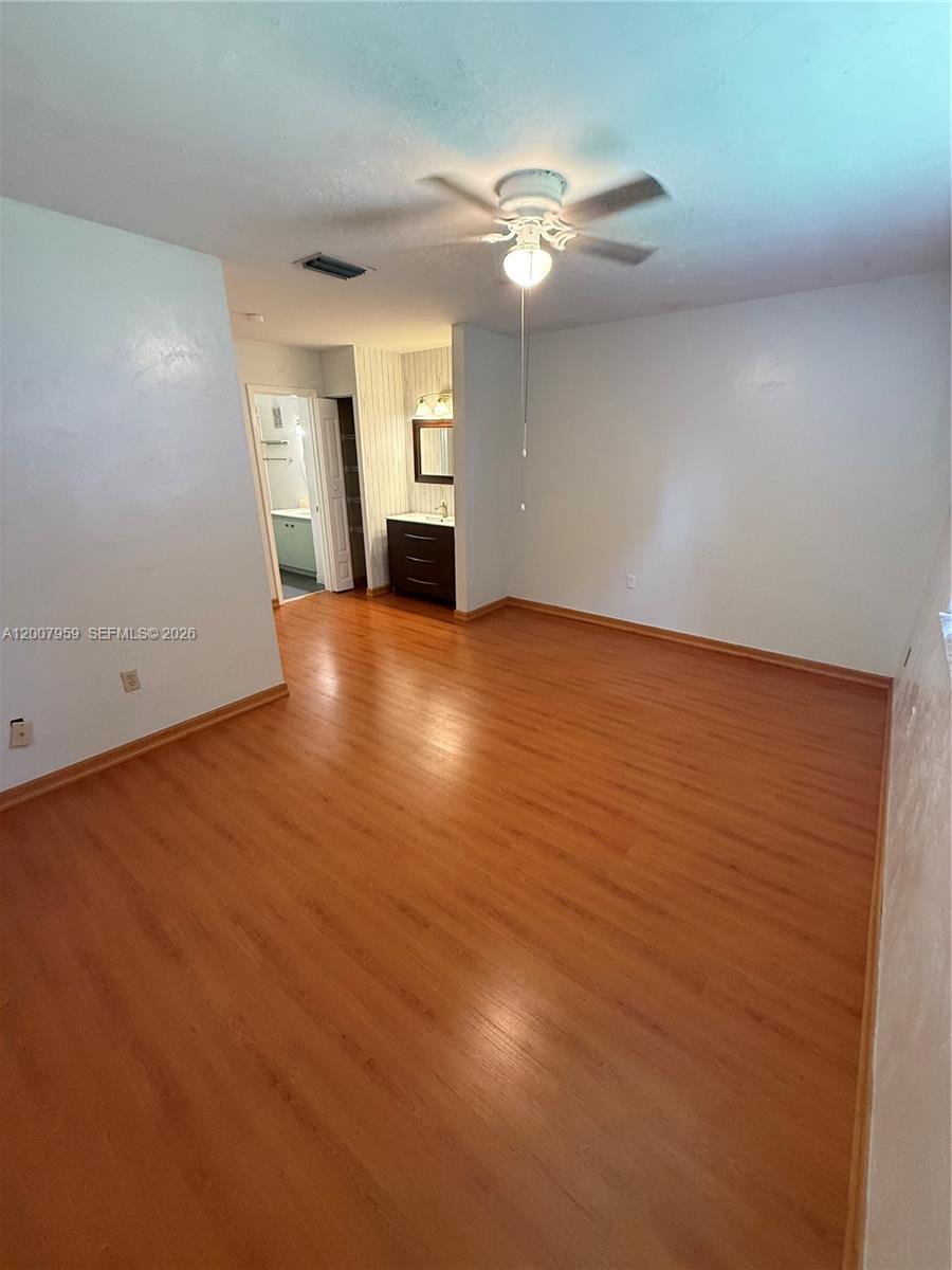 10661 Southwest 113th Place, Unit 94B Miami, FL 33176 - Photo 26 of 54 an empty room with chandelier fan and windows