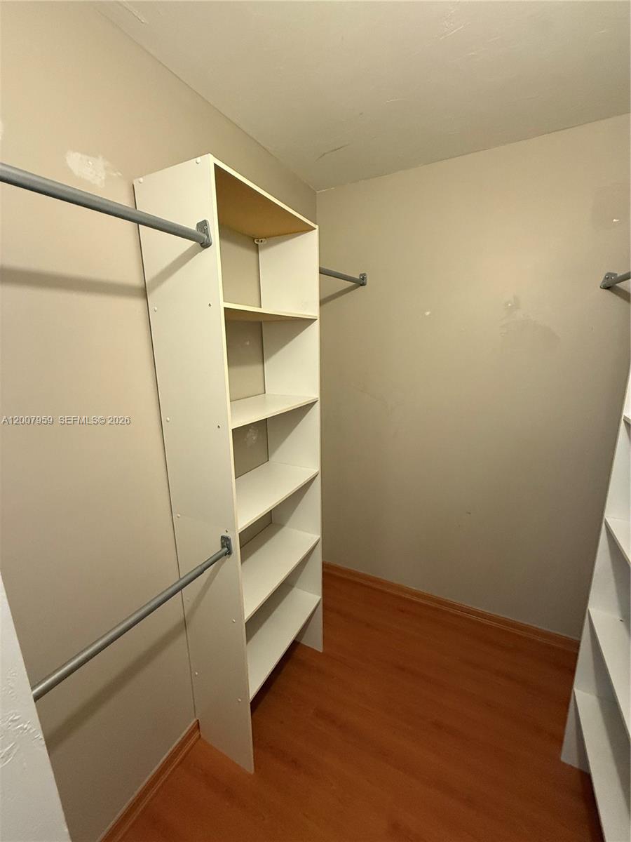 10661 Southwest 113th Place, Unit 94B Miami, FL 33176 - Photo 27 of 54 a view of walk in closet with empty racks