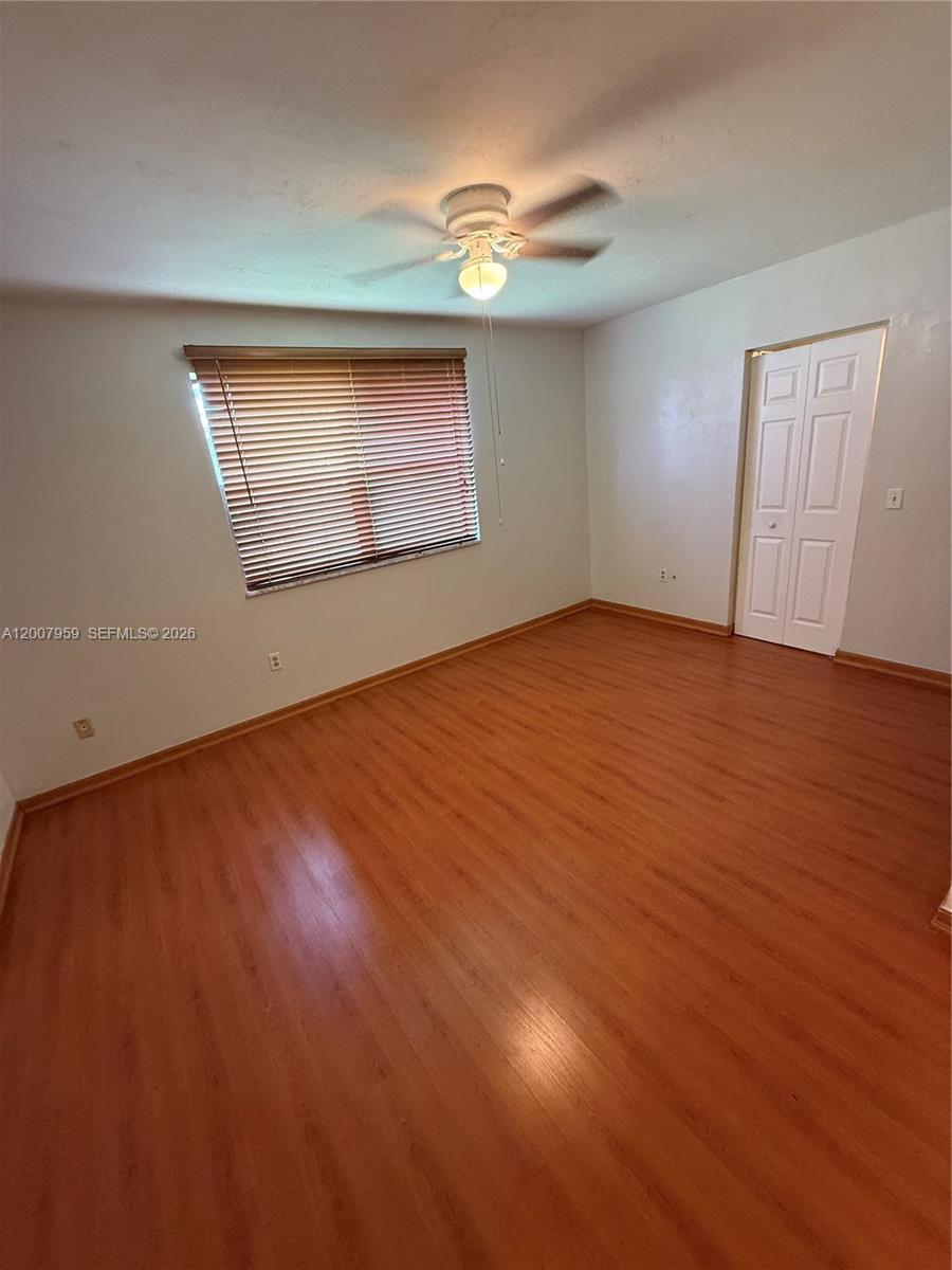 10661 Southwest 113th Place, Unit 94B Miami, FL 33176 - Photo 29 of 54 an empty room with wooden floor and windows